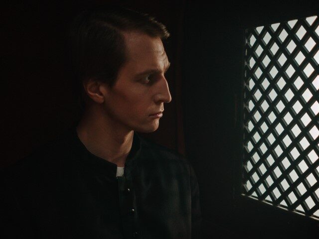 Священник в кабинке для исповеди.